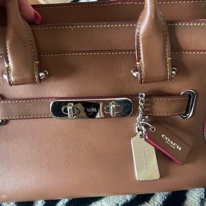 Classic coach has long strap or hold on arm .